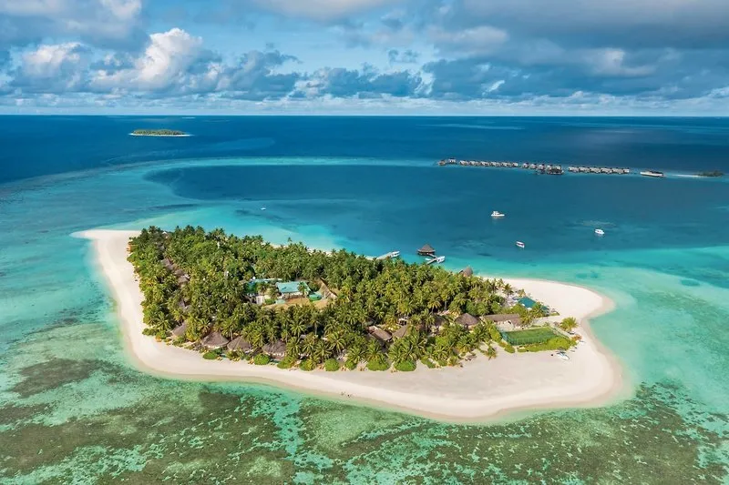 Zračni posnetek otoka Angsana Velavaru s turkizno laguno in vilami na vodi