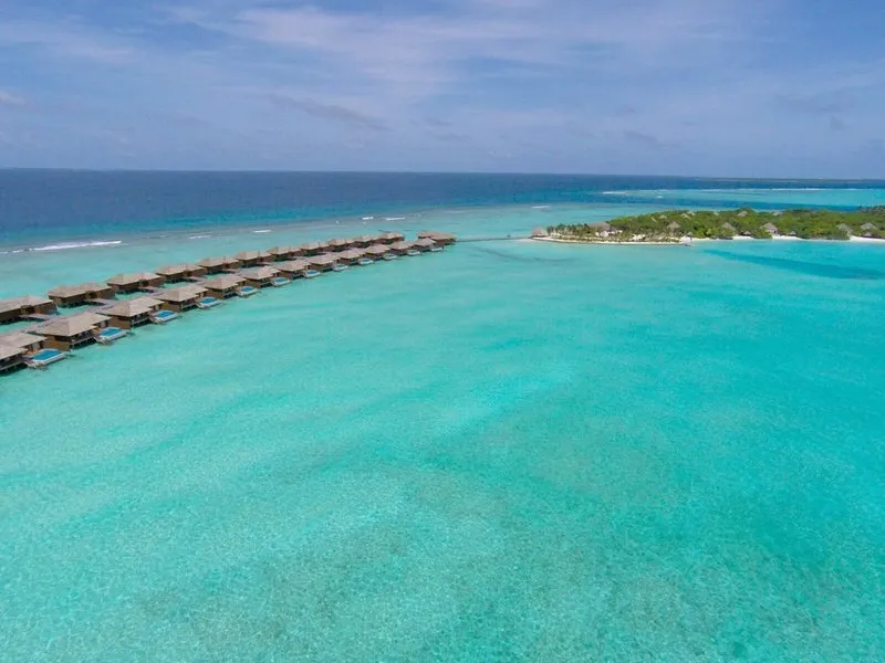 Zračni posnetek luksuznih vodnih vil in turkizne lagune Hideaway Beach