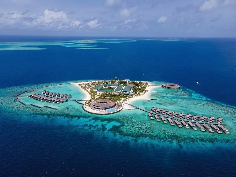 Letalski posnetek otoka Kagi Maldives Resort s turkizno laguno in nadvodnimi vilami