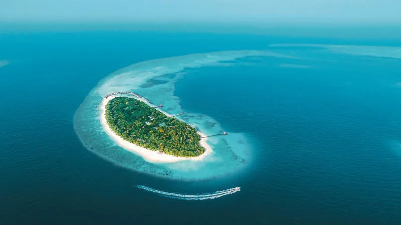 Zračni posnetek otoka NH Collection Maldives Reethi Resort s turkizno laguno